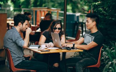 photo of three person sitting and talking